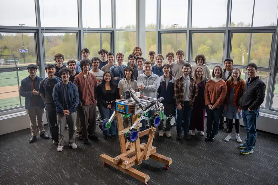 Team group photo in the ARC with the rover during its unveiling, 2025